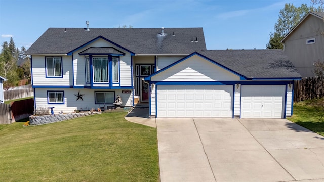 tri-level home with a garage, a shingled roof, driveway, and a front lawn