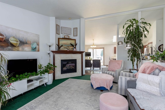 carpeted living area featuring a notable chandelier and a tile fireplace