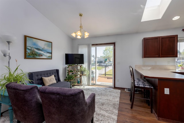 living area with an inviting chandelier, baseboards, lofted ceiling with skylight, dark wood-type flooring, and recessed lighting
