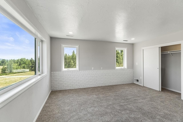 572 Smiley Ln, Newport, WA 99156 - unfurnished bedroom with a wainscoted wall, carpet, a textured ceiling, and visible vents