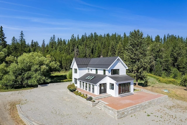 572 Smiley Ln, Newport, WA 99156 - view of front facade with dirt driveway, a porch, metal roof, and a forest view