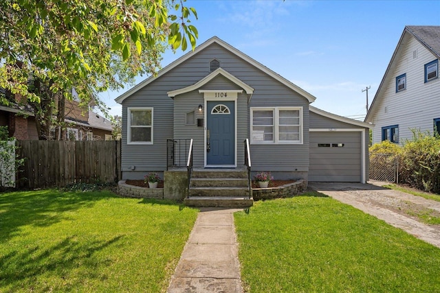 bungalow with a garage, fence, driveway, and a front yard