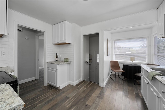 kitchen featuring white cabinets, dark wood finished floors, black electric range, baseboards, and tasteful backsplash