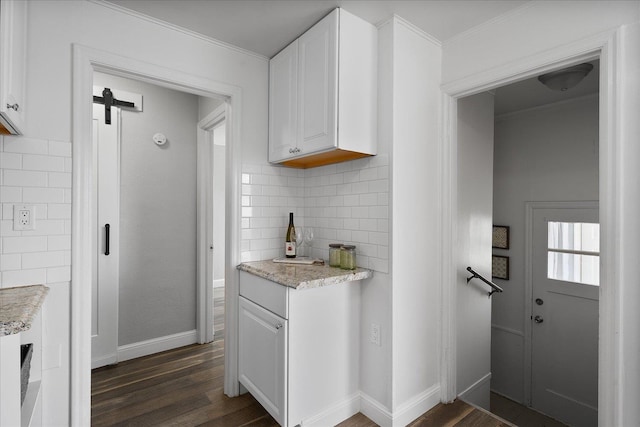 kitchen with crown molding, dark wood-style flooring, white cabinets, and tasteful backsplash
