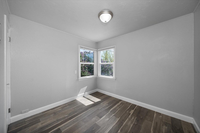 unfurnished room featuring dark wood-style flooring and baseboards
