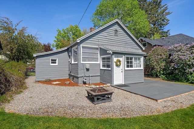 rear view of property with a patio, an outdoor fire pit, fence, and a chimney