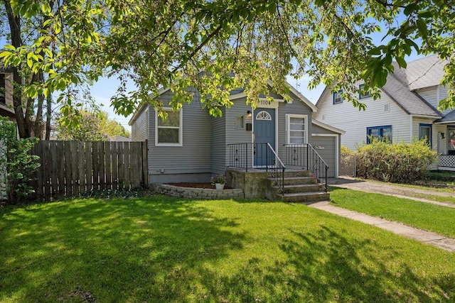 view of front facade featuring fence, driveway, a front yard, and a garage