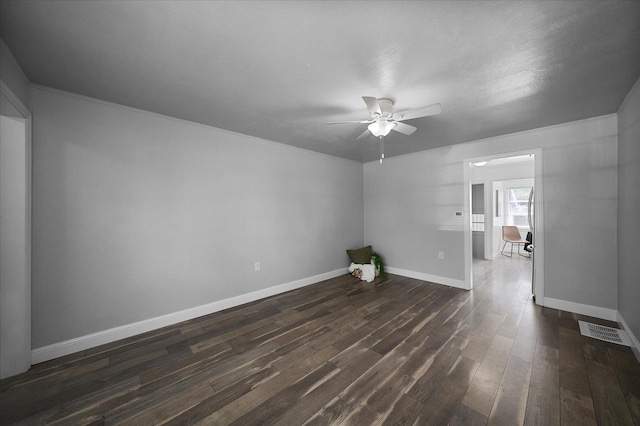 empty room featuring visible vents, baseboards, ceiling fan, and dark wood-style floors