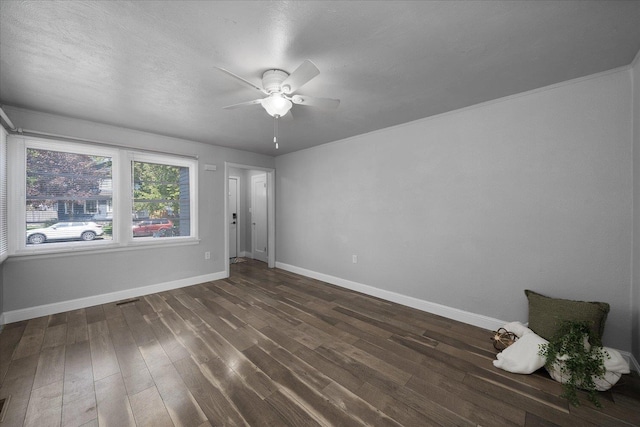 spare room featuring baseboards, a ceiling fan, wood finished floors, and visible vents