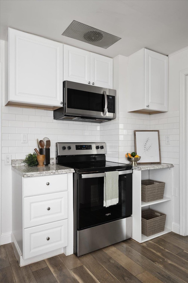 kitchen featuring decorative backsplash, appliances with stainless steel finishes, light stone counters, white cabinetry, and dark wood-type flooring