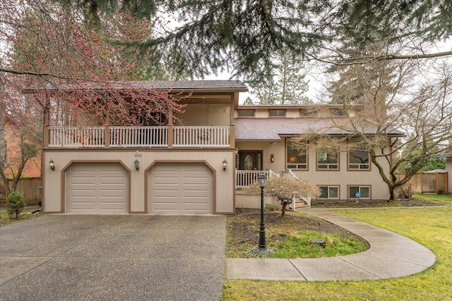 view of front of house featuring fence, a shingled roof, an attached garage, a balcony, and driveway