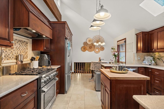 kitchen with vaulted ceiling with skylight, decorative backsplash, wooden counters, pendant lighting, and stainless steel appliances