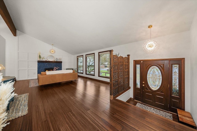 entryway featuring a notable chandelier, vaulted ceiling with beams, and wood finished floors