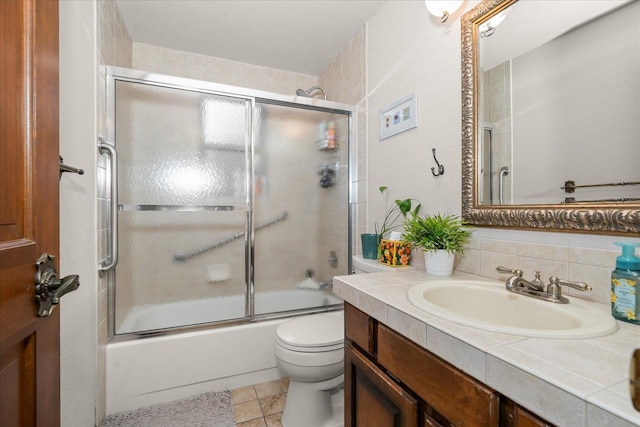 full bath with toilet, enclosed tub / shower combo, and vanity