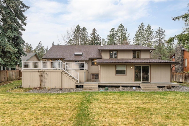 back of property featuring fence, a wooden deck, and a yard