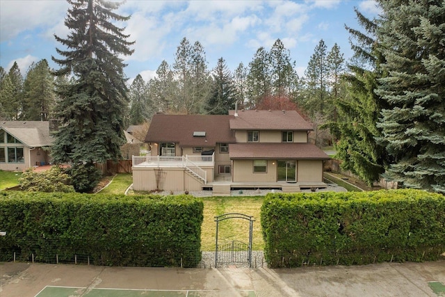 rear view of house with fence private yard, a wooden deck, stairs, a gate, and a shingled roof