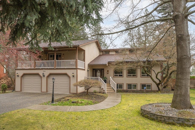 view of front facade featuring roof with shingles, a front lawn, aphalt driveway, a garage, and a balcony