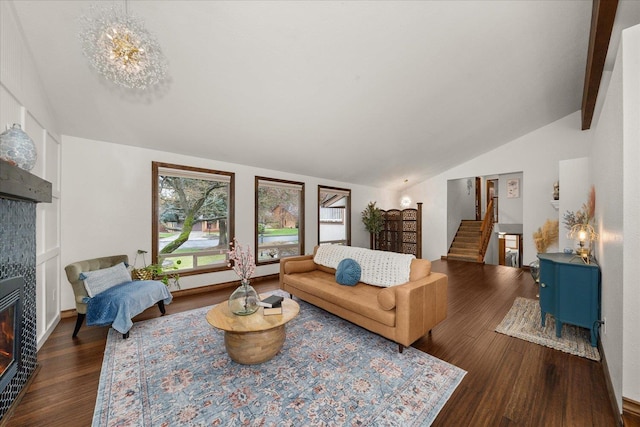 living room with a fireplace, stairway, lofted ceiling with beams, and wood finished floors