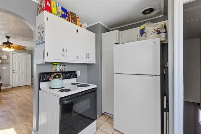 kitchen with a ceiling fan, range with electric cooktop, white cabinets, freestanding refrigerator, and light wood-style flooring