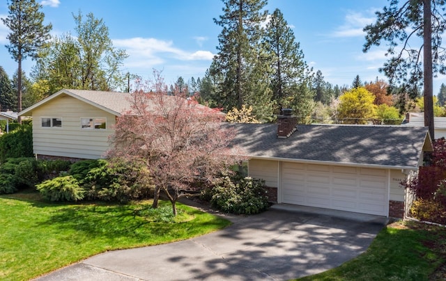 view of front of property with a front lawn, brick siding, a garage, a chimney, and driveway