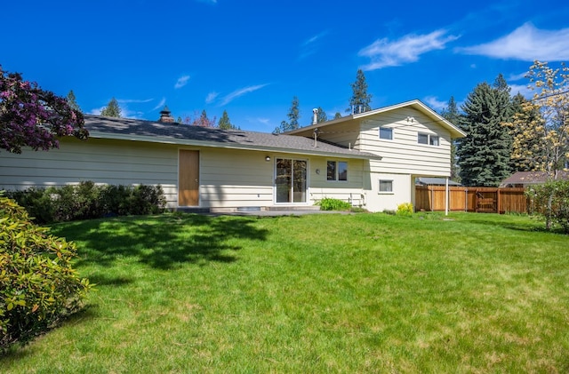back of house with fence and a yard
