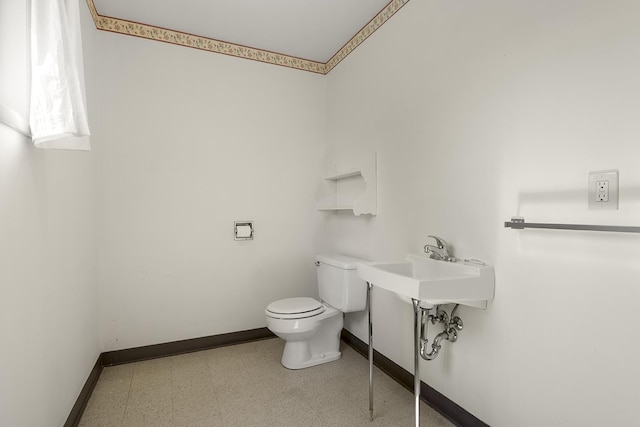 bathroom featuring toilet, baseboards, and tile patterned floors