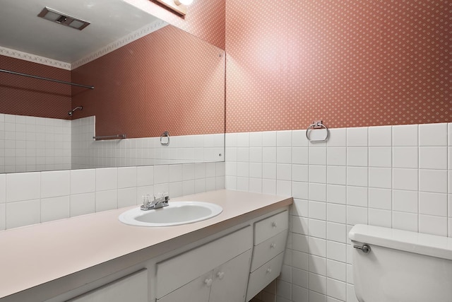 bathroom featuring walk in shower, tile walls, toilet, and wallpapered walls