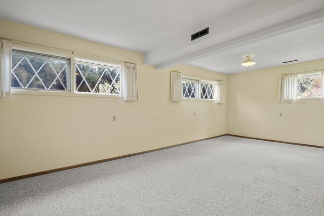unfurnished room featuring baseboards, carpet flooring, beam ceiling, and visible vents