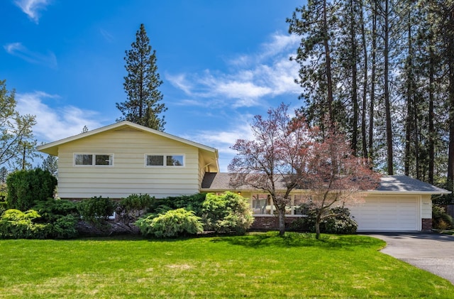 view of side of property with an attached garage, a lawn, brick siding, and concrete driveway