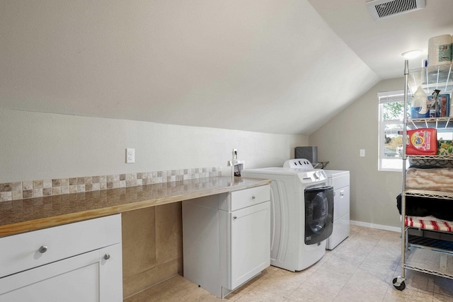 clothes washing area featuring light tile patterned floors, separate washer and dryer, cabinet space, and visible vents