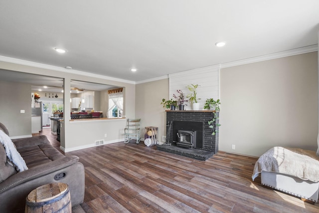 living area featuring crown molding, recessed lighting, wood finished floors, and visible vents