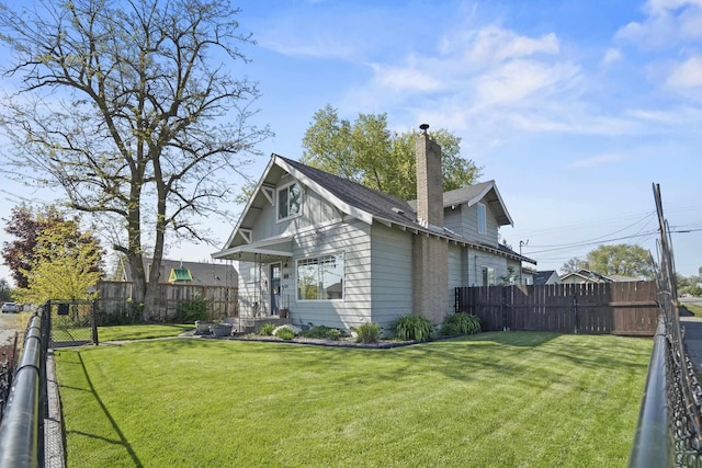 exterior space with a lawn, a chimney, and a fenced backyard