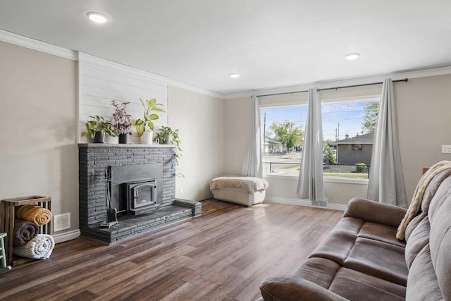 living area with crown molding, wood finished floors, and visible vents