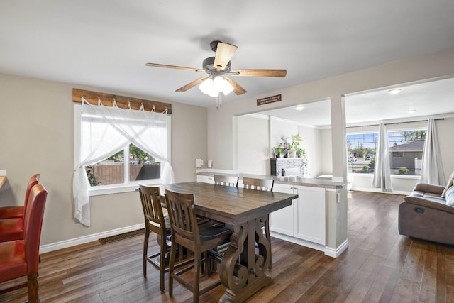 dining area featuring baseboards, ceiling fan, and dark wood-type flooring