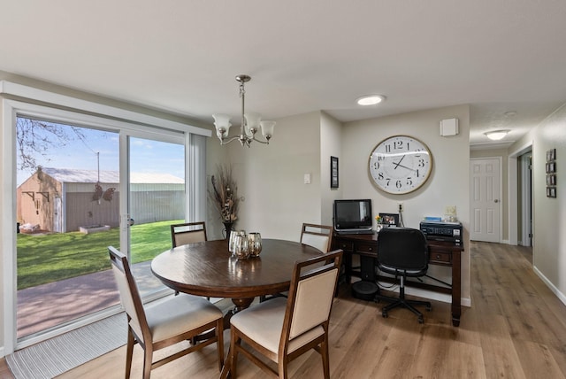 dining area with light wood finished floors and a notable chandelier