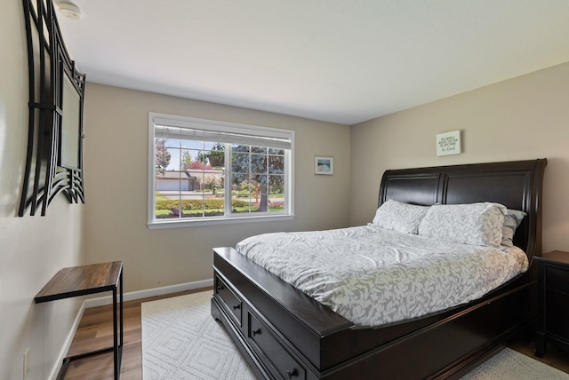 bedroom featuring baseboards and wood finished floors