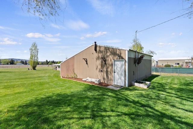 view of pole building with fence and a yard