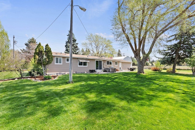 rear view of property featuring a yard, a patio, and fence
