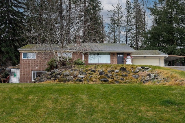 view of front of home with an attached carport, driveway, a front lawn, and brick siding