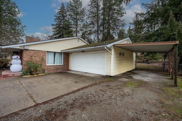 view of side of property featuring a garage, fence, a chimney, brick siding, and driveway
