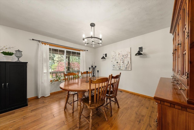 16503 N Mockingbird Ln, Nine Mile Falls, WA 99026 - dining space featuring an inviting chandelier, baseboards, and light wood-style flooring