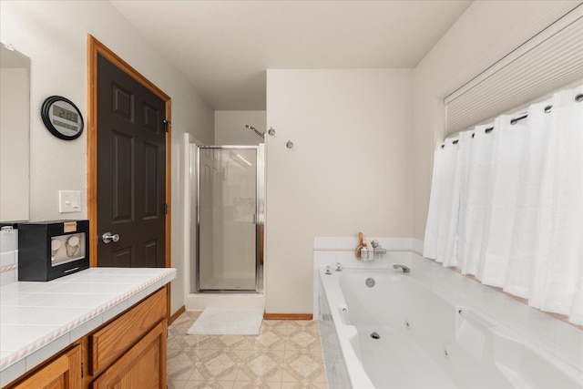 16503 N Mockingbird Ln, Nine Mile Falls, WA 99026 - full bathroom featuring a jetted tub, a stall shower, tile patterned floors, vanity, and baseboards