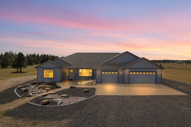 view of front of property with driveway, roof with shingles, and a garage