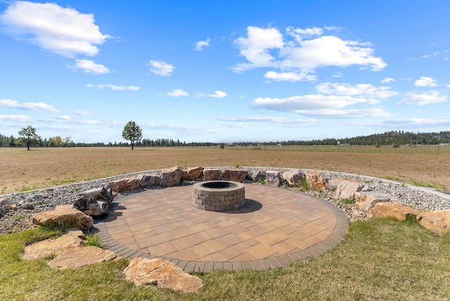 view of patio featuring an outdoor fire pit and a rural view