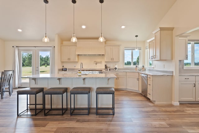 kitchen with plenty of natural light, stainless steel dishwasher, and custom exhaust hood