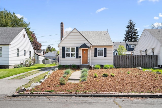 bungalow-style home featuring fence and a chimney