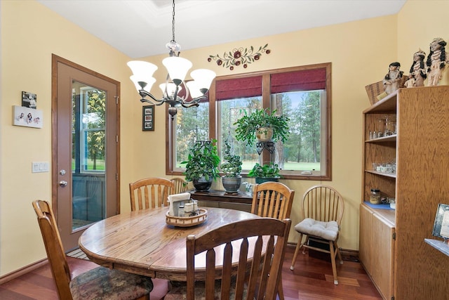 dining space with baseboards, a notable chandelier, and wood finished floors