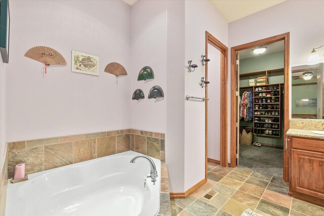 420 Palmer Ln, Chewelah, WA 99109 - full bath featuring a walk in closet, vanity, baseboards, stone finish flooring, and a garden tub