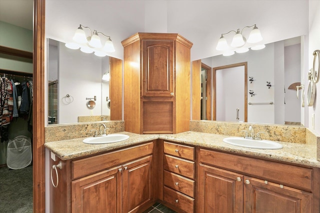 bathroom with double vanity, a walk in closet, and a sink