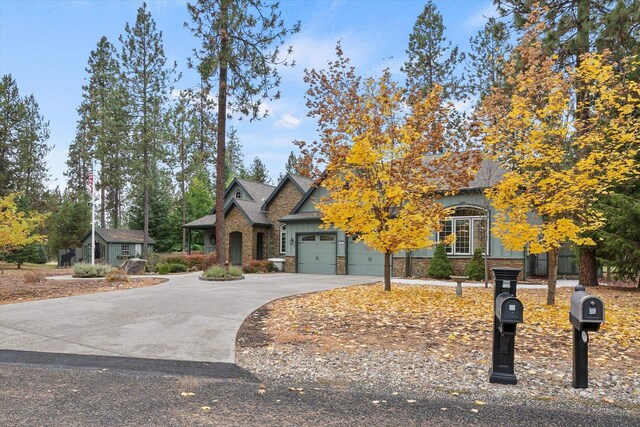 420 Palmer Ln, Chewelah, WA 99109 - view of front facade with an attached garage, driveway, and stone siding